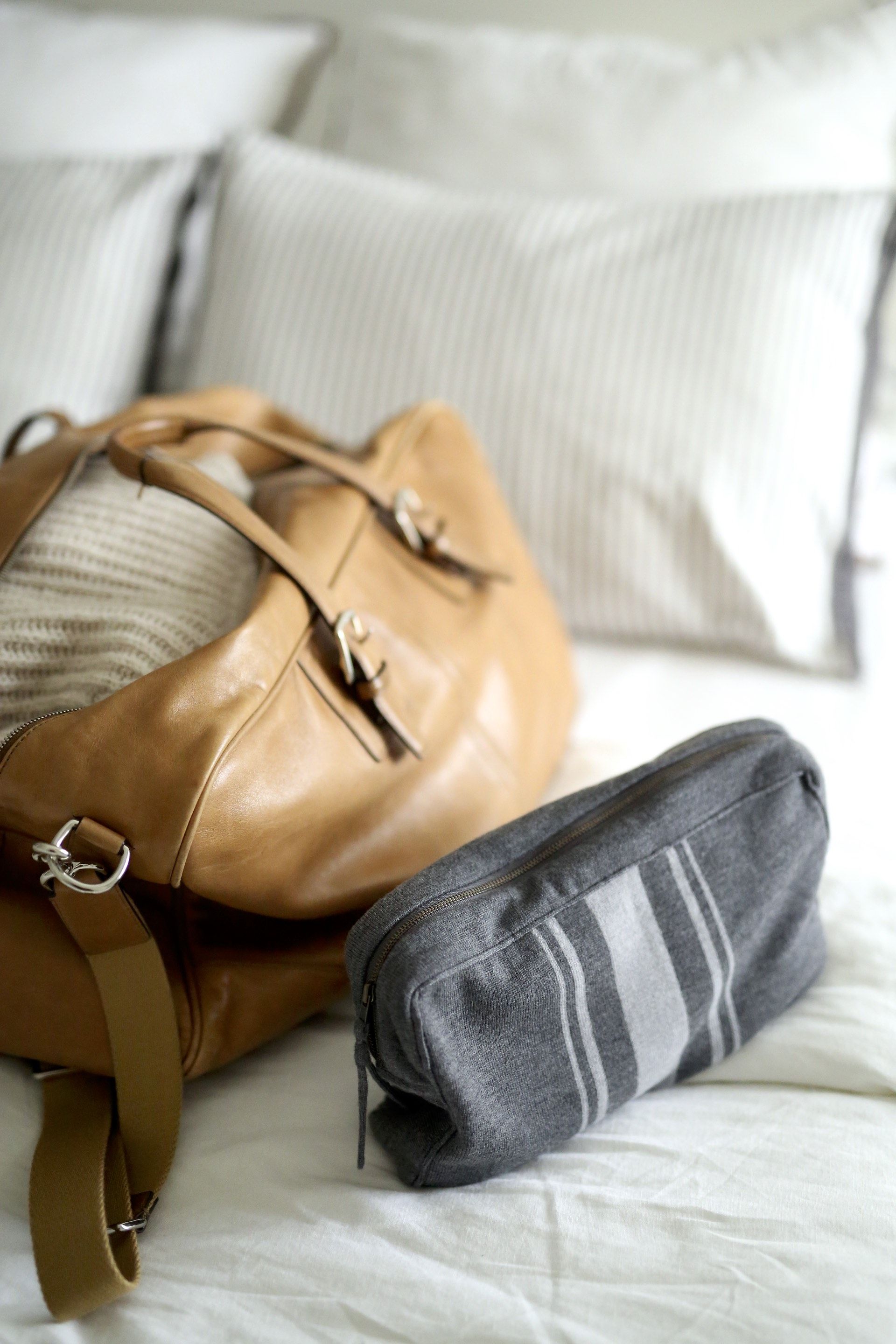 brown leather bag and gray merino wool travel kit by parachute home