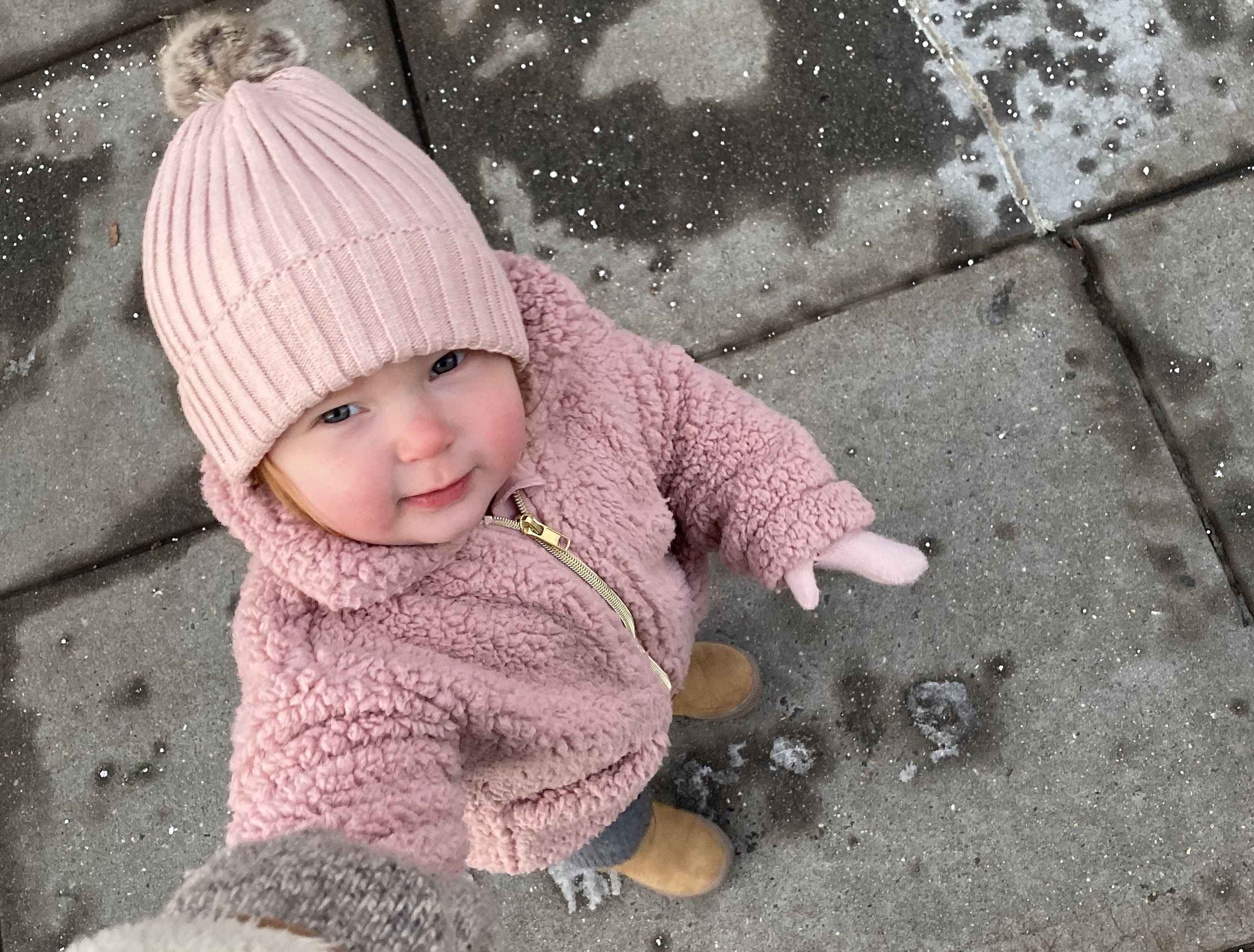 toddler wearing pink on sidewalk