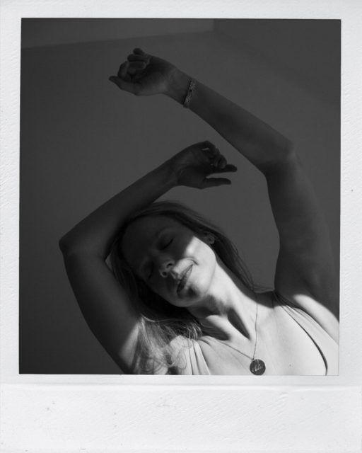 black and white photo of woman with arms in air