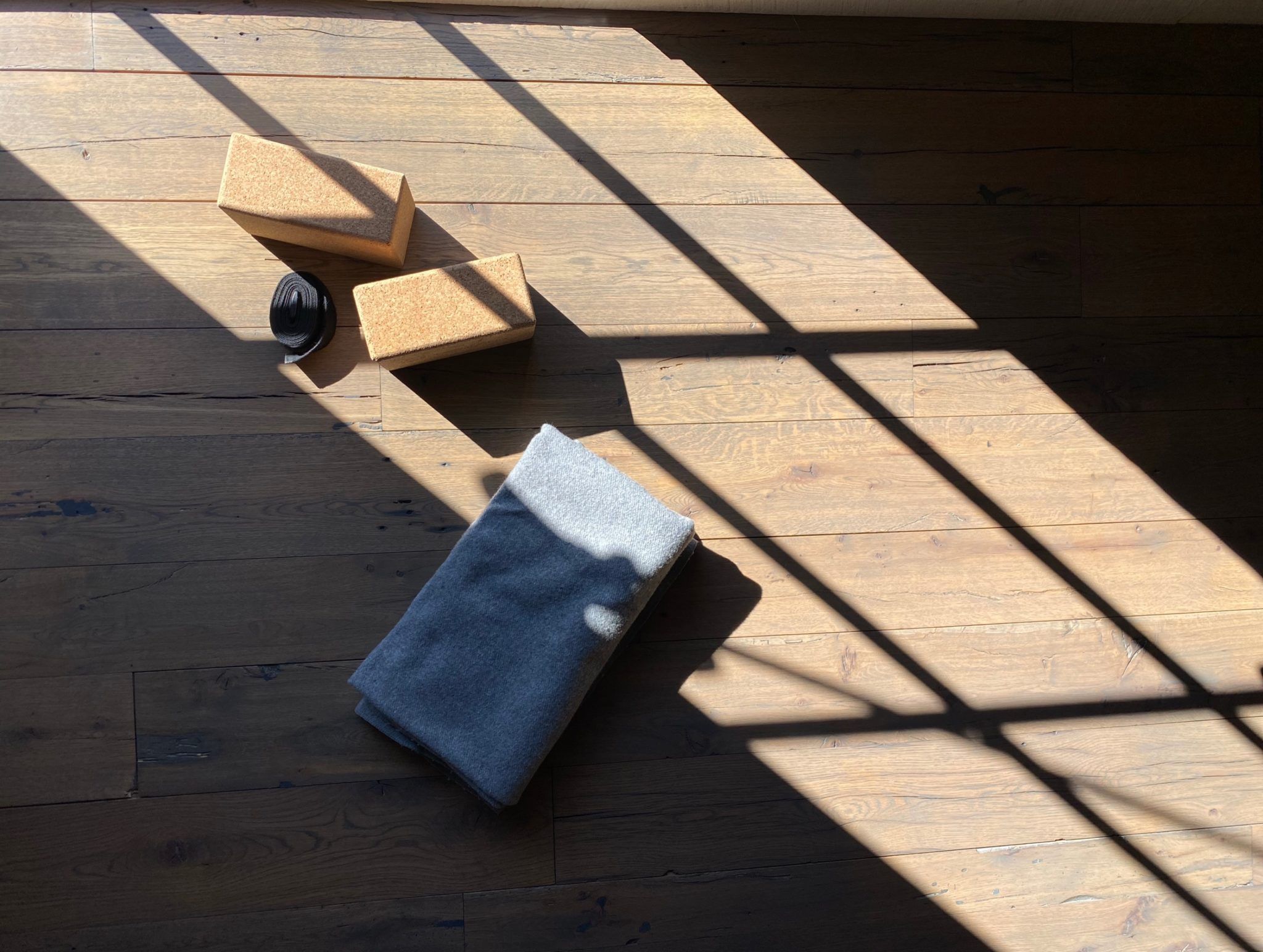 yoga blocks, strap, and blanket on the floor