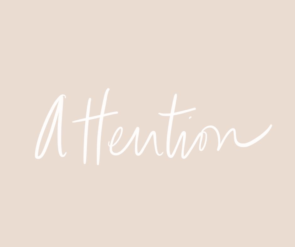 white handwriting that reads "Pay Attention" on blush background