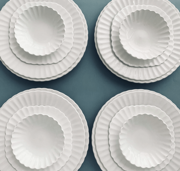 set of four white ironstone plates on blue tablecloth